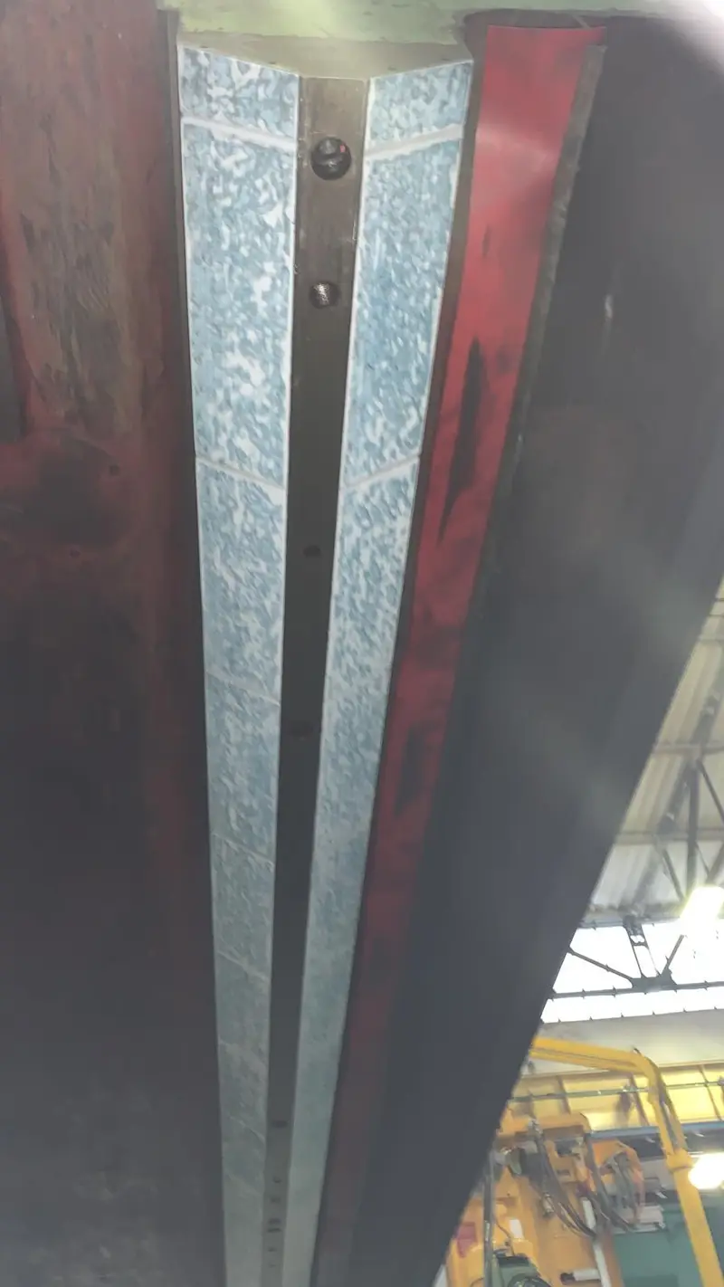 Guía prismática rasqueteada en una máquina pintada de rojo.