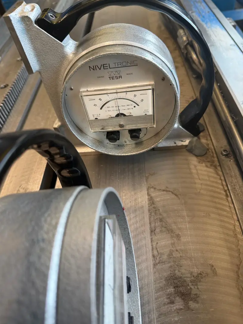 NIVELTRONIC de TESA con cable sobre la bancada de la máquina.