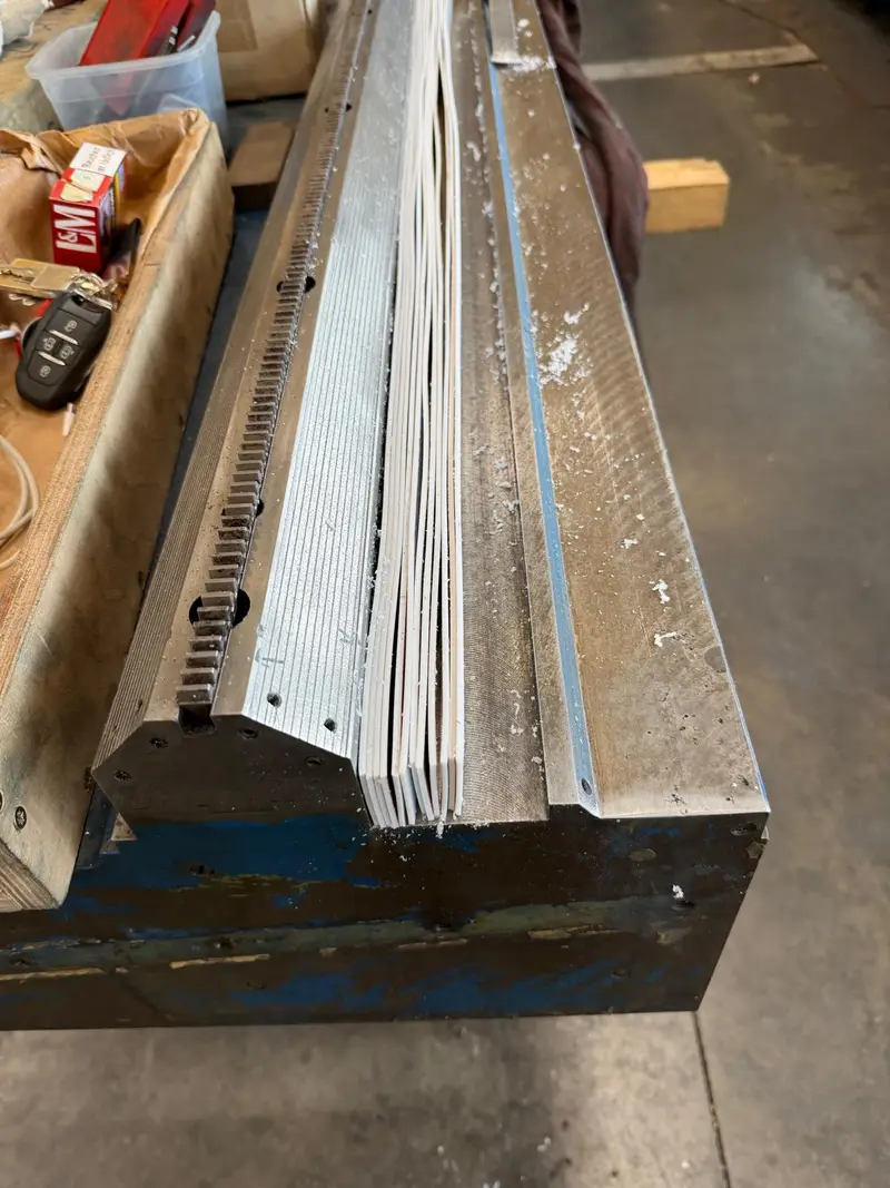 Bancada azul desmontada con cremallera, con las superficies de deslizamiento en metal desnudo.