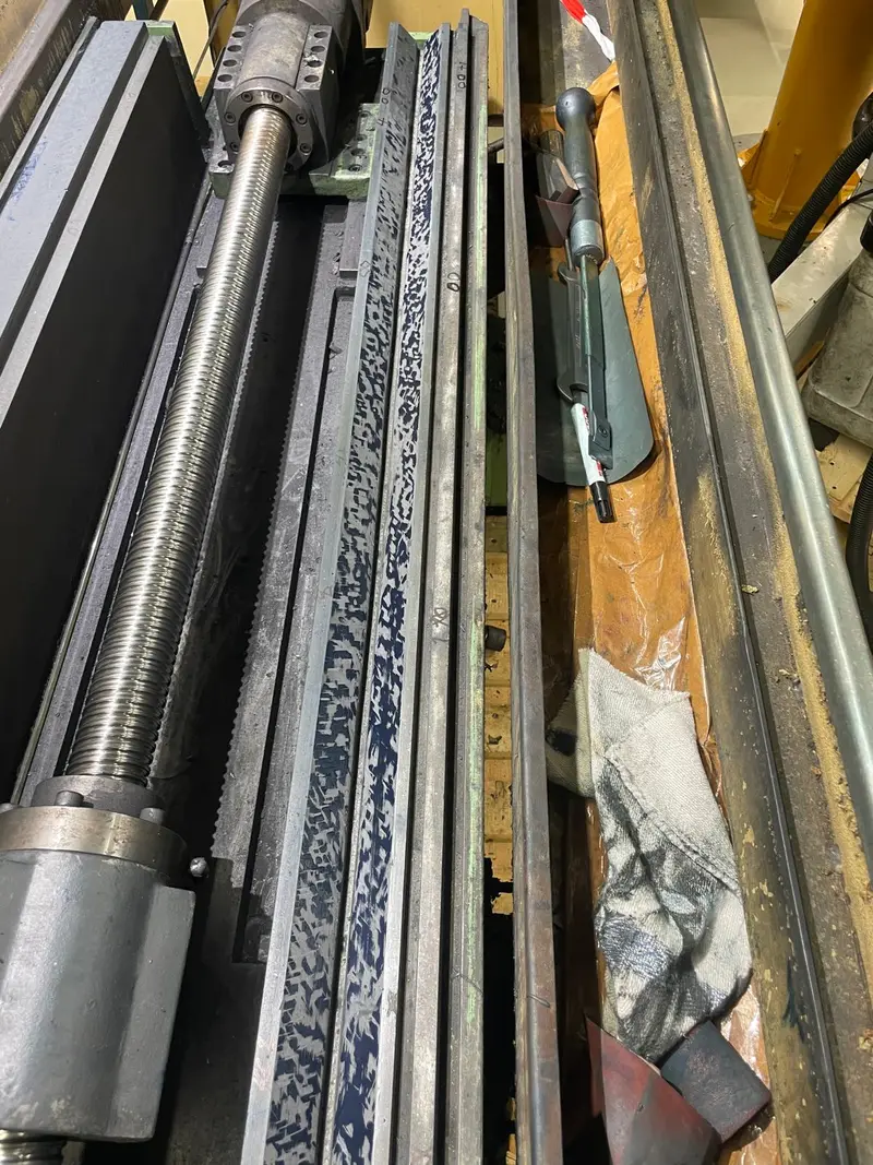 Primer plano de la guía y el husillo de bolas después del rasqueteado, con la guía marcada en azul.