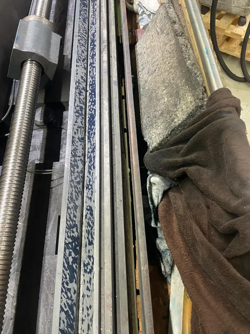 La guía junto al husillo de bolas después del rasqueteado, marcada en azul en toda su longitud.