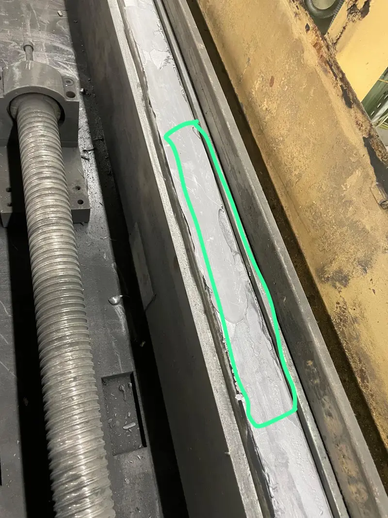Guía junto al husillo de bolas antes del trabajo, con la zona desgastada rodeada en verde.