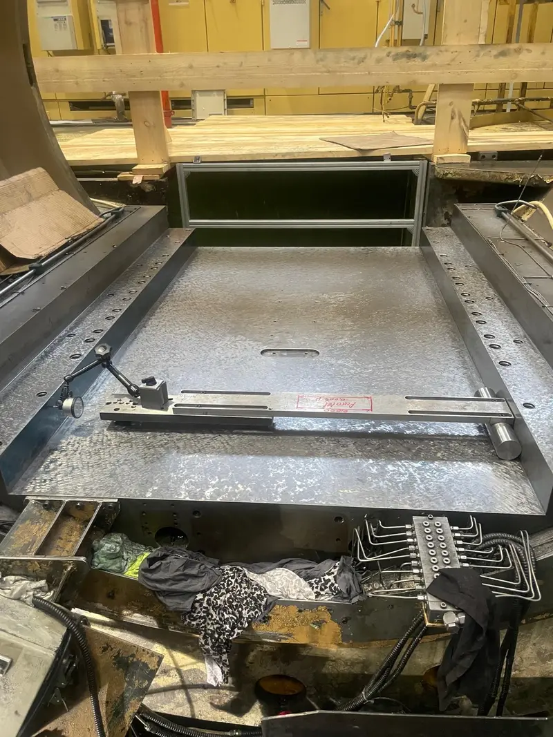 Máquina abierta con la mesa al descubierto y, encima, una regla.