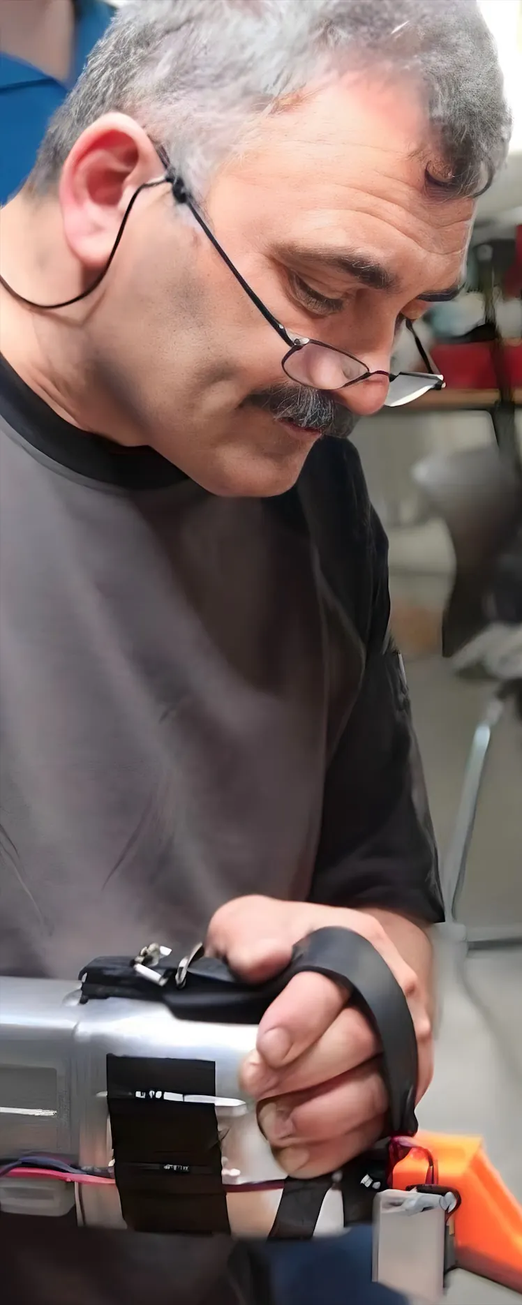 Kemal, über das Werkstück gebeugt, führt den Handschaber beidhändig über die Führungsbahn.